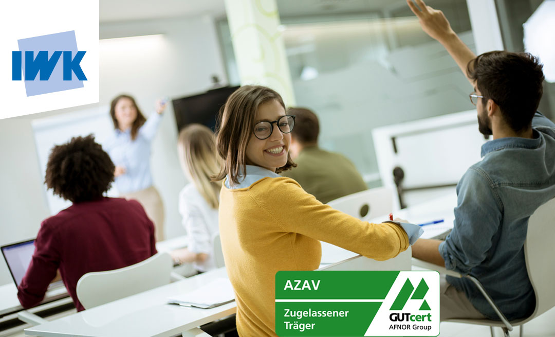 Eine Frau in einem gelben Pullover sitzt in einer Fortbildung, dreht um und lächelnd nach hinten in die Kamera. Unten rechts sieht man das AZAV Zertifikats-Logo